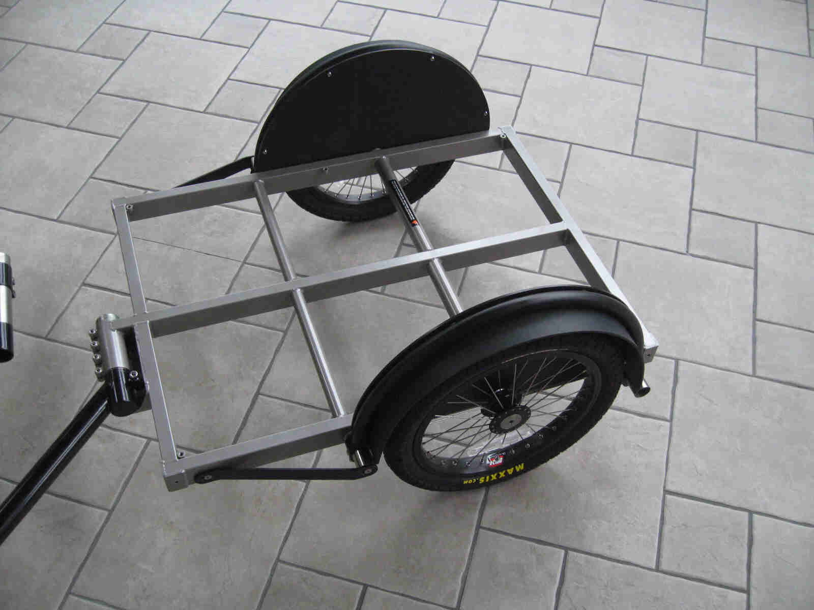 Downward, left side view of a Surly Bill or Ted bike trailer, on a tiled floor